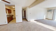 Located at 7717 Carrington in Madison, WI, this single-floor, two-bedroom, one-bathroom unit offers a functional and comfortable layout. The open living room is generously sized, featuring neutral wall-to-wall carpeting, baseboard heating, and a sliding glass door that fills the space with natural light while providing views of the surrounding area. A wall-mounted air conditioning unit adds year-round climate flexibility.

The kitchen is efficiently designed with tile flooring, warm oak cabinetry, laminate countertops, and a full suite of stainless steel appliances including an electric range, microwave, refrigerator, and dishwasher. A convenient passthrough connects the kitchen to the rest of the unit.

Both bedrooms are carpeted and bright, each featuring windows with red-trimmed frames that allow in natural light and baseboard heating units. The spacious primary bedroom includes a ceiling fan and access to a dedicated closet. The second bedroom is well-proportioned and similarly finished.

The full bathroom is finished with tile flooring, an oak vanity with a granite-style countertop, a large mirror, and a multi-bulb light fixture. Consistent warm wood tones and neutral finishes throughout the unit create a cohesive and welcoming ambiance.