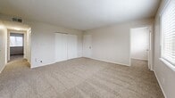 Located at 4424 NW Hon Dr in Riverside, Missouri, this single-floor unit features three bedrooms, two bathrooms, and a thoughtfully arranged layout that maximizes its compact footprint. The living room serves as the central gathering space, featuring plush carpeting, a ceiling fan, and multiple windows fitted with horizontal blinds that allow generous natural light to fill the room. An adjacent area with light wood-look flooring provides a seamless transition between spaces.

Each bedroom is carpeted and finished with neutral-toned walls and textured ceilings, contributing to a clean, consistent aesthetic. The spacious primary bedroom includes a full-width louvered closet and direct hallway access, while the secondary bedrooms each feature windows overlooking the exterior and convenient door access. The hallway connects the bedrooms efficiently to the rest of the unit.

The two bathrooms offer functional designs: one features a full tub-shower combination with white tile surround, a granite-topped vanity, and wood-look flooring, while the second is a more compact space with white tile wainscoting. Throughout the unit, white trim, neutral walls, and textured ceilings create a cohesive, understated ambiance.