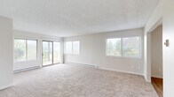 This single-floor, 3-bedroom, 2-bathroom home offers a practical and comfortable layout ideal for everyday living. The expansive living room is carpeted and bathed in natural light from multiple large windows and a sliding glass door that opens to an outdoor balcony, framing views of surrounding greenery. Baseboard heating runs throughout the carpeted living and bedroom areas, ensuring year-round comfort.

The kitchen is well-equipped with white cabinetry, light countertops, and black appliances including a refrigerator, electric range, and dishwasher. Light hardwood-style flooring adds warmth, and an adjacent dining area features a ceiling fan and additional window for natural light.

The primary bedroom is generously sized, featuring carpet flooring, a wide window with outdoor views, and a large walk-in closet with built-in shelving. The two additional bedrooms are also carpeted and well-lit. 

The two bathrooms include hardwood-style flooring and white cabinetry with brushed nickel hardware. One bathroom features a shower stall, while the other offers a full tub-shower combo. Both include a single vanity with a mirror. A hallway connects the main living spaces to the bedrooms and bathrooms, completing this well-organized, light-filled home.