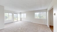 This single-floor, 3-bedroom, 2-bathroom home offers a practical and comfortable layout ideal for everyday living. The expansive living room is carpeted and bathed in natural light from multiple large windows and a sliding glass door that opens to an outdoor balcony, framing views of surrounding greenery. Baseboard heating runs throughout the carpeted living and bedroom areas, ensuring year-round comfort.

The kitchen is well-equipped with white cabinetry, light countertops, and black appliances including a refrigerator, electric range, and dishwasher. Light hardwood-style flooring adds warmth, and an adjacent dining area features a ceiling fan and additional window for natural light.

The primary bedroom is generously sized, featuring carpet flooring, a wide window with outdoor views, and a large walk-in closet with built-in shelving. The two additional bedrooms are also carpeted and well-lit. 

The two bathrooms include hardwood-style flooring and white cabinetry with brushed nickel hardware. One bathroom features a shower stall, while the other offers a full tub-shower combo. Both include a single vanity with a mirror. A hallway connects the main living spaces to the bedrooms and bathrooms, completing this well-organized, light-filled home.