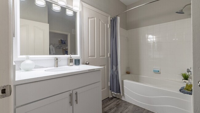 Baño moderno con espejo grande enmarcado y amplio espacio de almacenamiento - Enders Place at Baldwin Park