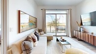 Located in Las Vegas, NV, this thoughtfully designed 2-bedroom, 2-bathroom residence offers a modern living experience across a single floor. The open-concept layout seamlessly connects the kitchen, dining, and living areas, creating a bright and airy atmosphere enhanced by light wood-style flooring throughout.

The contemporary kitchen is a standout feature, boasting sleek two-tone cabinetry with integrated under-cabinet lighting, quartz countertops, stainless steel appliances including a gas range, and a large island with bar seating — ideal for both cooking and entertaining.

The living room is anchored by expansive sliding glass doors that frame outdoor views and flood the space with natural light, complemented by a clean, neutral palette. Both bedrooms are well-proportioned, with large windows offering outdoor views and generous walk-in closets featuring built-in shelving and hanging rods. The primary bedroom provides a comfortable retreat with ample storage.

The two bathrooms are finished with modern vanities and warm gold hardware accents. One bathroom features a tiled soaking tub with elegant brushed gold fixtures, adding a refined touch. The cohesive design language throughout — white walls, warm wood tones, and contemporary fixtures — creates a polished, inviting ambiance suitable for modern living.