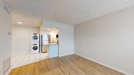 Located at 2630 NE 52nd Ct in Silver Springs, FL, this single-story residence offers a thoughtfully updated interior with a clean, neutral aesthetic throughout. Light wood-look flooring flows through the main living areas, complemented by white baseboards and a textured ceiling that adds a classic Florida feel. The open living space is bright and airy, with a large front window fitted with blinds that allows natural light to fill the room. A solid entry door provides a secure and welcoming entrance. The kitchen is efficiently designed and well-appointed, featuring crisp white shaker-style cabinetry, granite countertops with subtle speckled patterning, a tile backsplash, and a full suite of stainless steel appliances including a refrigerator, electric range, microwave, and dishwasher. A granite-topped breakfast bar connects the kitchen to the main living area. A stacked washer and dryer unit is conveniently located just off the kitchen on tile flooring, providing in-unit laundry. The bedroom offers a comfortable layout with a large closet featuring louvered bifold doors and a window with natural light. The full bathroom is finished with white tile, a granite-topped vanity with white cabinetry, a shower/tub combination, and a window for ventilation.