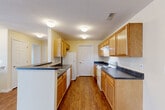 This compact yet well-designed 690 square foot single-story residence offers a harmonious blend of functionality and comfort. The home features one bedroom, measuring 110 square feet, and one bathroom, providing ample space for a single occupant or couple. The heart of the home is an open-concept living area that seamlessly combines the kitchen and living room, creating a spacious feel despite the modest square footage.

The kitchen is a standout feature, boasting honey-toned wood cabinetry that provides generous storage. Contrasting dark countertops and white appliances, including a range and dishwasher, complete the modern aesthetic. A convenient breakfast bar separates the kitchen from the living area, offering additional dining space.

Throughout the home, warm wood-look flooring unifies the space and adds a touch of elegance. Large windows in the bedroom and living area flood the interior with natural light, while horizontal blinds offer privacy control. The bathroom continues the home's color scheme with wood cabinetry and a dark countertop.

A notable amenity is the in-unit laundry room, equipped with full-sized washer and dryer, adding significant convenience to daily life. The overall design prioritizes efficiency without sacrificing style, making excellent use of the available space. This property, located at 1530 Blackbird Lane in Howell, MI, presents an ideal option for those seeking a low-maintenance yet comfortable living solution.