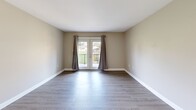 Located at 724 Teasel Dr in Kingsport, Tennessee, this one-bedroom, one-bathroom residence offers a well-organized single-floor layout with a clean, modern aesthetic throughout. Light-toned luxury vinyl plank flooring flows consistently across every room, creating a cohesive and easy-to-maintain living environment.

The combined kitchen and living area serves as the heart of the home. The kitchen is outfitted with rich dark-stained cabinetry, granite-look countertops, a stainless steel sink, a wall-mounted range hood, and white appliances including a range and full-size refrigerator. The adjacent living area is open and bright, anchored by a set of glass French doors that lead to a private balcony, bringing in natural light and offering views of the surrounding neighborhood.

The spacious primary bedroom provides a comfortable retreat, featuring a generously sized sliding-door closet and a window that allows for natural light. Neutral-toned walls throughout the home lend a calm, versatile backdrop suitable for a variety of furnishing styles.

The bathroom is finished with a full-size soaking tub and shower combination, a toilet, and brushed nickel hardware accents, all set against light walls and matching LVP flooring. A hallway connects the main living spaces, completing the efficient and practical floor plan of this Kingsport residence.