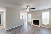 Located at 10 Rimington Ln in Decatur, GA, this one-bedroom, one-bathroom residence offers a well-designed single-floor layout that maximizes functionality and comfort. The living room serves as the heart of the home, featuring durable hardwood-style flooring, a ceiling fan with light kit, a textured ceiling, and a classic wood-burning fireplace framed by a clean white mantel — an inviting focal point for the space. Natural light filters in through multiple windows fitted with blinds. The galley-style kitchen is thoughtfully appointed with white shaker cabinetry, stone-look countertops, a double-basin sink, subway tile backsplash, and a full suite of stainless steel appliances including a refrigerator, electric range, microwave, and dishwasher. A pass-through connects the kitchen to the combined dining area. The bedroom is a comfortable size, fitted with its own ceiling fan and sliding glass doors that open directly onto a private balcony with outdoor views. Three closets — including a well-organized walk-in with wire shelving — provide generous storage throughout. The bathroom includes a full tub-and-shower combination with tiled surround. A dedicated laundry area houses a full-size Whirlpool washer and dryer, completing this practical and move-in-ready home.