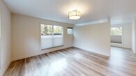 Located at 15948 Quarry Rd in Lake Oswego, Oregon, this thoughtfully designed one-bedroom, one-bathroom unit offers a clean, modern aesthetic throughout its efficiently laid-out single floor. Light wood-style flooring flows seamlessly through every room, creating a warm and cohesive feel that brightens the entire space.

The main living area is bathed in natural light from large windows fitted with cellular shades, offering views of lush surrounding greenery. A flush-mount light fixture adds to the welcoming ambiance. A wall-mounted mini-split unit provides efficient heating and cooling year-round. The layout opens naturally toward a compact kitchen featuring warm wood cabinetry, a subway tile backsplash, and stainless steel appliances, including a range and microwave.

A central hallway connects the living and sleeping areas, maintaining a logical and functional flow. The bedroom is generously proportioned, featuring multiple windows that frame peaceful tree-lined views and fill the room with soft, natural light.

The bathroom is finished with tasteful, contemporary materials, including a wood-toned vanity with stone-look countertops, light tile flooring, and a large built-in storage closet with clean white panel doors. A window above the toilet introduces additional natural light into the space. Every detail reflects a commitment to modern comfort and understated elegance.
