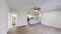 Located at 1104 Jasmine Cove Cir in Simpsonville, SC, this single-floor residence offers a thoughtfully designed open-concept layout. The combined dining and living area features wood-look flooring, neutral-toned walls, a ceiling fan, and French doors that invite natural light and provide outdoor access. The kitchen is a functional centerpiece, equipped with stainless steel appliances including a refrigerator, electric range, and built-in microwave, complemented by white cabinetry, dark countertops, and a peninsula that connects seamlessly to the living space. A dedicated utility room adds practical convenience. The bedroom is a comfortable retreat featuring plush carpeting, vaulted ceilings, a ceiling fan, and a window with outdoor views. Four closets throughout the unit provide generous storage capacity. The bathroom includes a full tub-shower combination with tiled surround. Recessed lighting, textured ceilings, and consistent neutral finishes contribute to a clean, cohesive aesthetic throughout the home. The overall design prioritizes functionality while maintaining a bright and welcoming ambiance.