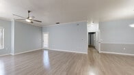 Located in Tampa, FL, this single-story residence offers a thoughtfully designed layout that balances comfort and functionality. The open-concept living and dining area is finished with light wood-look flooring, soft blue-gray walls, crown molding, and ceiling fans, creating a bright and airy atmosphere enhanced by natural light from large windows with vertical blinds.

The kitchen is well-appointed with white cabinetry, dark granite-style countertops, a subway tile backsplash, white appliances including a refrigerator and electric range, and a double-basin sink. A peninsula with overhead pendant lighting connects the kitchen to the main living space.

The bedrooms feature plush carpeting, ceiling fans, and generous walk-in closet space with built-in shelving. The primary bathroom is a standout, offering both a separate glass-enclosed shower and a soaking tub finished in white tile, complemented by clean, neutral finishes throughout.

Additional highlights include a dedicated in-unit laundry room with a full-size washer and dryer, a door providing direct exterior access from the living area, and consistent soft blue-gray paint throughout that lends the home a cohesive, modern feel. The overall design is clean, functional, and move-in ready.