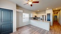 Located in Colorado Springs, CO, this well-designed 2-bedroom, 2-bathroom single-floor residence offers a clean, modern aesthetic with thoughtful finishes throughout. The open-concept living and kitchen area serves as the heart of the home, featuring durable wood-look plank flooring, recessed lighting, and a ceiling fan. The kitchen is equipped with stainless steel appliances—including a refrigerator with ice maker, electric range, microwave, and dishwasher—complemented by white cabinetry, a gray tile backsplash, and a granite-look peninsula countertop that provides additional seating and workspace. A wall-mounted mini-split system ensures efficient climate control in the living area. Both bedrooms are carpeted for comfort and include wall-mounted mini-split units, ceiling fans or lighting, and closets with built-in shelving. The primary bedroom benefits from natural light through a large window. The bathrooms feature wood-look tile flooring and walk-in showers with clean, simple fixtures. Throughout the home, neutral tones and consistent design choices create a cohesive, move-in-ready atmosphere ideal for comfortable everyday living.