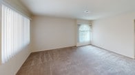 Located at 1301 E Commonwealth Ave in Fullerton, California, this single-story unit offers a practical and well-organized layout. The kitchen is equipped with a stainless steel gas range, an over-the-range microwave, and ample cabinetry finished in a neutral tone. A double-basin sink sits beneath recessed lighting, and light tile flooring keeps the area clean and easy to maintain. A ceiling fan overhead provides additional air circulation.

The bathroom features a full-size soaking tub with a tub-and-shower combination, clean white tile surround, and chrome fixtures, presenting a simple and functional design.

The living area is generously proportioned, finished with wall-to-wall carpeting and neutral beige walls that create a bright, open feel. A large window dressed with vertical blinds allows natural light to filter in, offering views of the surrounding greenery. A ceiling fan with integrated lighting adds comfort to the space.

The bedroom mirrors this clean aesthetic, also featuring plush carpeting, vertical blind-covered windows that invite natural light, and a closet for ample storage. The unit's consistent use of neutral tones, ceiling fans, and natural light throughout gives the space a calm, livable ambiance suited for everyday comfort.