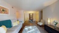 This single-floor residence offers a thoughtfully designed layout that balances comfort and functionality. The open-concept living and dining area serves as the heart of the home, featuring warm wood-look flooring that flows seamlessly throughout the main spaces. The living room provides ample room for relaxing and entertaining, with a large window that invites natural light and views of the outdoors.

Adjacent to the living area, the dining space is defined by an overhead pendant light fixture and connects directly to the kitchen, making it ideal for everyday meals. The kitchen is well-equipped with white cabinetry, granite-style countertops, stainless steel appliances including a refrigerator, microwave, dishwasher, and gas range, all set atop durable wood-look flooring.

The bedroom is a comfortable retreat featuring plush carpeting, a ceiling fan with integrated lighting, and two generous closets with bifold doors offering ample storage. A window allows natural light to fill the room. The full bathroom includes a combined tub and shower with clean white surrounds, complemented by wood-look flooring. A dedicated laundry area with an in-unit washer adds everyday convenience to this well-rounded residence.