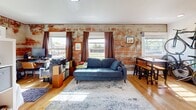 Located at 622 Euclid Ave, Unit 302 in Des Moines, Iowa, this efficiently designed single-floor unit offers a thoughtful layout that maximizes every square foot of its intimate footprint. The living area is the standout centerpiece of the space, featuring a striking exposed brick wall that lends an industrial-chic character to the room. Warm hardwood flooring flows throughout, complemented by multiple windows that usher in abundant natural light and provide views of the surrounding neighborhood. The kitchen is well-appointed with white shaker-style cabinetry, stainless steel appliances including a gas range, refrigerator, dishwasher, and microwave, along with a full countertop workspace and a single-basin sink — all finished with recessed lighting overhead. The bathroom offers a clean, modern aesthetic with a white vanity, a mirrored medicine cabinet, tiled flooring, and a shower with a decorative curtain. A dedicated entryway area provides additional utility with wall hooks and space for storage. The overall ambiance of the unit is bright and functional, blending classic architectural details like the exposed brick with updated modern finishes throughout.