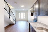 Located at 1534 N Capitol St NW in Washington, DC, this two-story residence offers 2 bedrooms and 2 bathrooms spread across two thoughtfully laid-out floors. The main level features an open-concept living, dining, and kitchen area bathed in natural light, with warm hardwood-style flooring flowing throughout. The kitchen is outfitted with dark cabinetry, granite-style countertops, a tile backsplash, and stainless steel appliances, creating a sleek, functional space. A modern staircase with a contemporary metal railing connects the two levels, adding an architectural focal point to the main living area. The upper floor hosts the bedrooms, each benefiting from natural light through large windows with neighborhood views. The primary bedroom offers a comfortable footprint with dedicated closet space. Both bathrooms are finished with clean tile flooring, dark wood vanities, white countertops, and full tub-shower combinations. With four closets distributed throughout, storage is plentiful. The unit's clean, neutral palette, consistent hardwood-style flooring, and modern fixtures create a cohesive and contemporary ambiance throughout.