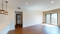 Located in the vibrant Hollywood neighborhood of Los Angeles, this single-floor residence at 6900 Bonita Terr offers a thoughtfully designed interior with modern finishes. Rich hardwood flooring flows throughout the main living areas, creating a warm and cohesive aesthetic. The open-concept living area is bright and airy, highlighted by recessed lighting and a striking stacked-stone accent wall that adds texture and visual interest. Large windows and a glass door invite natural light and provide views of the surrounding neighborhood, including glimpses of palm trees. The kitchen is well-appointed with dark espresso cabinetry, white quartz countertops, stainless steel appliances including a gas range, microwave, refrigerator, and dishwasher, and a deep single-basin sink with a modern faucet. Stylish pendant lights hang above the peninsula, which offers casual seating and open sightlines to the living space. The bedroom features hardwood flooring, a sliding mirrored closet, and a window framing outdoor greenery. Two bathrooms are finished with tile flooring, white subway-tiled tub-shower combos, and clean, neutral palettes. A dedicated laundry closet with a stacked washer and dryer adds everyday convenience to this well-designed Los Angeles home.