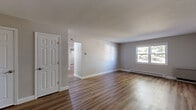 Located at 110 Colleen Rd in Troy, NY, this single-floor, three-bedroom, one-bathroom home offers a well-organized and functional layout with modern updates throughout. The living room greets you with warm hardwood-style flooring, neutral gray walls, and a bright window that fills the space with natural light. A baseboard heating system runs throughout, ensuring year-round comfort.

The kitchen is a standout feature, outfitted with slate-blue shaker-style cabinetry, white countertops, and a full suite of stainless steel appliances including a refrigerator, electric range, over-the-range microwave, and dishwasher. A ceiling fan adds airflow and a light wood floor complements the contemporary cabinetry.

Three bedrooms provide flexible living options. The spacious primary bedroom is carpeted and includes a closet, while the two additional bedrooms feature hardwood-style flooring and windows with natural views of surrounding greenery. Each room benefits from clean, neutral tones and baseboard heating.

The bathroom is neatly finished with light wood-style flooring, a gray vanity with a white basin, a framed mirror, and brushed nickel fixtures. White six-panel doors are consistent throughout the home, contributing to a cohesive and clean aesthetic.