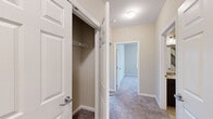This single-floor residence offers a thoughtfully designed layout across two bedrooms, two bathrooms, a kitchen, living room, hallway, dedicated laundry room, and a closet. The kitchen is a standout feature, equipped with dark espresso cabinetry, granite countertops, a subway tile backsplash, stainless steel appliances including a refrigerator, range, and microwave, and a breakfast bar that opens to the adjacent living area. The spacious living room is carpeted and bathed in natural light, featuring sliding glass doors that lead to a private balcony overlooking lush greenery. Both bedrooms are generously sized with plush carpeting and neutral tones, offering a calm and comfortable atmosphere. The primary bedroom includes access to a walk-in closet with built-in shelving. Both bathrooms are finished with warm tile flooring, dark vanity cabinetry, granite countertops, and well-lit mirrors. The dedicated laundry room houses a full-size washer and dryer and features tile flooring for easy maintenance. Throughout the residence, neutral wall tones, clean white trim, and consistent finishes create a cohesive and move-in-ready environment.