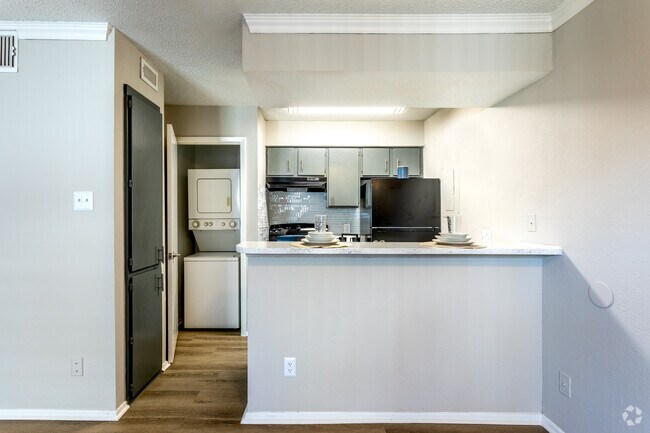 Cocina contemporánea con barra de desayuno y diseño abierto - Fountains of Jupiter Apartments