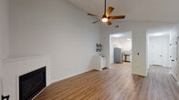 Located at 750 Boone Station Dr in Burlington, NC, this single-floor home offers a well-designed layout with a clean, neutral aesthetic throughout. The living room is a standout space, boasting dramatic vaulted ceilings, warm wood-look flooring, and a corner fireplace that serves as a natural focal point. A ceiling fan with a wood-tone finish adds a classic touch, while a glass-paneled door allows natural light to flow in and provides outdoor access. The kitchen is thoughtfully appointed with white shaker-style cabinetry, granite countertops with subtle veining, a stainless steel sink with a matte black faucet, and stainless steel appliances including a refrigerator, dishwasher, and range. The bedrooms feature plush carpet flooring and ceiling fans, with several rooms offering arched windows that bring in natural light and views of the surrounding landscape. The bathrooms are finished in crisp white, with a tub-shower combination and hardwood-style flooring. Throughout the home, the consistent use of white walls and bright finishes creates a cohesive, light-filled atmosphere that feels open and welcoming.