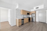 Located on Venice Blvd in the heart of Venice, Los Angeles, this thoughtfully designed 2-bedroom, 1-bathroom unit offers a clean, modern aesthetic across a single floor. Light wood-tone flooring runs seamlessly throughout, creating a warm and cohesive atmosphere.

The kitchen is a standout feature, outfitted with flat-front light wood cabinetry, white quartz countertops, and a subway-tile backsplash. Stainless steel appliances — including a gas range, built-in microwave, dishwasher, and refrigerator — provide a fully functional and contemporary cooking space.

Both bedrooms are bright and minimalist, with crisp white walls and windows that invite ample natural light. The primary bedroom includes a sleek glass sliding door, adding a modern touch, while views of surrounding greenery can be enjoyed from the secondary bedroom window.

The bathroom is clean and well-appointed, featuring a combination tub and shower enclosed by a glass sliding door, with marble-look tile surround, a wall-mounted vanity with light wood cabinetry, and a large mirror. The overall design of this unit emphasizes simplicity, natural light, and modern finishes, making it a bright and functional living space in a prime Los Angeles location.