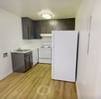 This recently updated apartment in Knoxville, Tennessee, showcases a thoughtful layout and modern amenities. The kitchen is a standout feature, boasting sleek dark gray cabinets, white appliances, and a practical design that maximizes space. The light wood-look flooring in the kitchen and living area adds warmth and durability.

The bedrooms are generously sized, featuring plush carpeting and ample natural light through large windows with blinds. Built-in closets provide convenient storage solutions. The bathroom is efficiently designed with a single vanity, mirror, and necessary fixtures, all in a clean, white palette.

The living area is particularly noteworthy, with its hardwood-style flooring and large windows that flood the space with natural light. This room offers versatility for various furniture arrangements. A unique architectural feature is the two-story window in what appears to be a stairwell or entryway, adding an element of grandeur to the space.

Throughout the apartment, recessed lighting and simple flush-mount fixtures provide ample illumination. The neutral color scheme, predominantly in whites and light grays, creates a blank canvas for personal decor preferences. This one-floor layout offers ease of movement and a sense of openness, making it an ideal living space for various lifestyles.