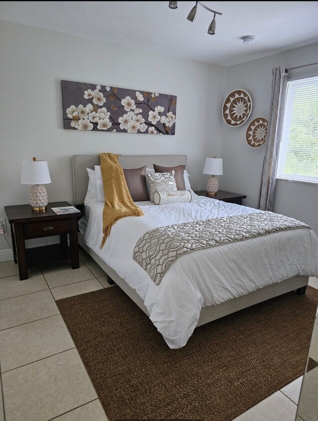 Spacious room with a queen size bed and a large window that beautifully lights up the room. - 7702 NE 3rd Ct