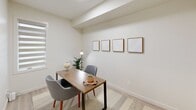 Located in Edmonton's north end at Admiral Girouard Street, this well-designed one-bedroom, two-bathroom unit offers a thoughtful single-floor layout with a bright, contemporary aesthetic throughout. The open-concept living area seamlessly connects the kitchen, dining, and living spaces, all finished with light-toned luxury vinyl plank flooring and recessed lighting. The kitchen is equipped with stainless steel appliances — including a French door refrigerator, electric range, built-in microwave, and dishwasher — complemented by white flat-panel cabinetry, a subway tile backsplash, and a quartz-style countertop with a breakfast bar island for casual dining. Large windows flood the living area with natural light, creating an airy and welcoming ambiance. The dedicated dining space adjoins the living room, which opens to a private balcony overlooking the surrounding residential neighbourhood. The primary bedroom is a comfortable retreat with direct access to a walk-in closet and an ensuite bathroom featuring a glass-enclosed shower. A second full bathroom includes a soaker tub and shower combination. Additional highlights include three closets for ample storage, an in-suite laundry area, and a versatile den area suitable as a home office.