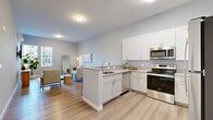 Located at 33 Old Tavern Rd in Orange, CT, this thoughtfully designed 2-bedroom, 2-bathroom residence offers a clean, modern aesthetic across a single, well-organized floor. The open-concept kitchen and living area serves as the heart of the home, featuring crisp white shaker cabinetry, light quartz countertops, a peninsula with an undermount sink, and a full suite of stainless steel appliances including a refrigerator, range, microwave, and dishwasher. Warm hardwood-style flooring flows seamlessly throughout the space, complementing the soft gray walls and bright, neutral palette. The living room offers generous natural light through large windows and provides a comfortable, versatile layout. The spacious primary bedroom is a serene retreat, featuring dual windows with outdoor views, ample room for furnishings, and access to a dedicated walk-in closet with built-in wire shelving. Both bathrooms are finished with gray shaker-style vanities, large mirrors, and walk-in glass-door showers set atop elegant tile flooring. A second well-proportioned bedroom adds flexibility for guests or a home office. The overall ambiance is fresh, contemporary, and move-in ready.