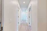 Located in Denver's vibrant Park Hill neighborhood, this thoughtfully designed 2-bedroom, 2-bathroom residence offers a clean, modern aesthetic throughout its well-appointed single floor. Light-toned hardwood flooring flows seamlessly across the living spaces, complementing the bright, neutral palette that defines the home's interior.

The open-concept living, dining, and kitchen area forms the heart of the home. The kitchen is outfitted with sleek white flat-panel cabinetry extending to the ceiling, stainless steel appliances including a French-door refrigerator and electric range, a herringbone tile backsplash, and a center island with a quartz countertop. Large windows and a sliding glass door in the living area flood the space with natural light and open to a private balcony with open green views.

The spacious primary bedroom enjoys ample natural light through tall windows with outdoor treetop views. Both bedrooms feature generous closets, including a walk-in closet with built-in shelving and hanging rods. The two bathrooms are finished with large-format tile flooring and clean white vanities. A dedicated laundry area and a bright hallway with recessed lighting and matte black door hardware complete this well-organized, move-in-ready home.