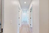 Located in Denver's vibrant Park Hill neighborhood, this thoughtfully designed 2-bedroom, 2-bathroom residence offers a clean, modern aesthetic throughout its well-appointed single floor. Light-toned hardwood flooring flows seamlessly across the living spaces, complementing the bright, neutral palette that defines the home's interior.

The open-concept living, dining, and kitchen area forms the heart of the home. The kitchen is outfitted with sleek white flat-panel cabinetry extending to the ceiling, stainless steel appliances including a French-door refrigerator and electric range, a herringbone tile backsplash, and a center island with a quartz countertop. Large windows and a sliding glass door in the living area flood the space with natural light and open to a private balcony with open green views.

The spacious primary bedroom enjoys ample natural light through tall windows with outdoor treetop views. Both bedrooms feature generous closets, including a walk-in closet with built-in shelving and hanging rods. The two bathrooms are finished with large-format tile flooring and clean white vanities. A dedicated laundry area and a bright hallway with recessed lighting and matte black door hardware complete this well-organized, move-in-ready home.