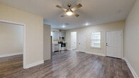 Located in Houston, TX, this well-appointed single-story home offers two bedrooms, two bathrooms, a kitchen, dedicated laundry room, and two closets — all finished with a consistent, modern aesthetic. Rich wood-look flooring flows throughout every room, providing a cohesive and durable foundation underfoot.

The kitchen is a functional highlight, featuring gray shaker-style cabinetry, granite-look countertops, a stainless steel refrigerator, dishwasher, microwave, and range. A window above the sink allows natural light to brighten the workspace, while ample cabinetry provides generous storage.

Both bedrooms are comfortably sized, with the primary bedroom offering a notably spacious layout. Each room features ceiling fans with light fixtures, neutral warm-toned walls, and windows with blinds that invite natural light. The closets are equipped with built-in shelving and hanging rods for organized storage.

The two bathrooms are identically finished with gray vanity cabinetry, granite countertops, tiled tub-shower surrounds, and wood-look flooring — delivering a clean, modern look. A dedicated laundry room houses a full-size top-load washer and dryer, adding everyday convenience to this thoughtfully designed home.