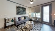 This thoughtfully designed single-floor residence offers a cohesive blend of modern aesthetics and functional living. The living room sets a sophisticated tone with crown molding, a ceiling fan, bold geometric area rug, and large windows fitted with textured Roman shades that invite natural light while maintaining privacy. A curated mix of contemporary furnishings and statement artwork enhances the space's visual appeal.

The kitchen is outfitted with crisp white cabinetry, granite countertops, a soft aqua glass tile backsplash, and a full suite of stainless steel appliances, including a French door refrigerator, electric range, built-in microwave, and dishwasher. Wood-look flooring ties the kitchen together with a clean, modern feel.

Two well-proportioned bedrooms each feature plush carpet, ceiling fans, and ample natural light. The primary bedroom offers a serene retreat, while the second bedroom provides equally comfortable accommodations with generous storage access.

The primary bathroom impresses with a dual-sink granite vanity, modern white cabinetry, wood-look flooring, and a walk-in glass shower. A second full bathroom includes a soaking tub, granite-topped vanity, and built-in open shelving for added storage and display. Together, these spaces offer a refined and comfortable living environment.