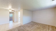 Located in Jacksonville, FL, this single-story, 2-bedroom, 1-bathroom home offers a practical and functional layout. The living room features neutral-toned carpet, textured ceilings, and a front entry door flanked by a window fitted with vertical blinds, allowing natural light to filter in. The galley-style kitchen is efficiently designed with white cabinetry, brown laminate countertops, a full suite of white appliances including a dishwasher, refrigerator, and electric range, and light tile flooring that extends into the adjacent areas. The primary bedroom is generously sized, featuring carpet flooring, a ceiling fan, a window overlooking greenery, and a built-in closet with sliding doors and integrated shelving and drawers for ample storage. The second bedroom also offers carpet flooring, textured ceilings, and a ceiling fan. The full bathroom is finished with beige wall tile, a tub-shower combination, a vanity with storage, and tile flooring. Throughout the home, consistent use of light, neutral tones creates a clean and cohesive aesthetic. Textured ceilings are present throughout all rooms, lending a uniform character to the interior.