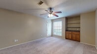 Located at 501 Napa Valley Dr in Little Rock, Arkansas, this single-floor unit offers a functional and comfortable layout designed for everyday living. The open living area is finished with neutral-toned carpet and painted walls, and is equipped with a ceiling fan with light fixture. A door with an adjacent window allows natural light to fill the space, creating a bright and welcoming atmosphere. Built-in shelving and warm wood cabinetry in one corner of the living area provide convenient storage and display options. The galley-style kitchen features warm oak cabinetry, granite-style countertops, a double stainless steel sink, a white electric range with overhead ventilation, and wood-look flooring that adds warmth underfoot. A dedicated laundry area is accessible directly from the kitchen. The bedrooms are carpeted and well-lit, each outfitted with ceiling fans and windows that bring in natural light. The full bathroom includes a wood-look vinyl floor, an oak vanity with granite-style countertop, a toilet, and a tiled tub-shower combination. Throughout the unit, neutral warm tones and consistent finishes create a cohesive, practical living environment suited for comfortable daily life.
