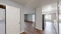 This single-floor residence offers a clean, modern aesthetic defined by cool gray walls, crisp white trim, and wood-look flooring that flows throughout the main living areas. The entry hall connects seamlessly to the open living and dining spaces, where large sliding glass doors invite natural light and provide outdoor views. A ceiling fan anchors the living area, adding both comfort and style.

The galley-style kitchen is well-equipped with white cabinetry extending to the ceiling for generous storage, light countertops, a stainless steel refrigerator, dishwasher, and range. The layout is efficient and practical, with ample counter space for meal preparation.

The bedrooms are carpeted for comfort, featuring neutral tones, windows with outdoor views, and white six-panel doors that maintain the home's consistent design language. Each bedroom offers a quiet, functional retreat.

Two full bathrooms serve the residence, each featuring a tub-shower combination enclosed by sliding glass doors with chrome hardware, wood-look flooring, and neutral wall tones that give each space a clean, contemporary feel.

Throughout the home, a cohesive color palette of soft grays and whites creates a calm, inviting atmosphere. The thoughtful layout and consistent finishes make this a practical and comfortable single-floor living space.