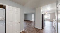 This single-floor residence offers a clean, modern aesthetic defined by cool gray walls, crisp white trim, and wood-look flooring that flows throughout the main living areas. The entry hall connects seamlessly to the open living and dining spaces, where large sliding glass doors invite natural light and provide outdoor views. A ceiling fan anchors the living area, adding both comfort and style.

The galley-style kitchen is well-equipped with white cabinetry extending to the ceiling for generous storage, light countertops, a stainless steel refrigerator, dishwasher, and range. The layout is efficient and practical, with ample counter space for meal preparation.

The bedrooms are carpeted for comfort, featuring neutral tones, windows with outdoor views, and white six-panel doors that maintain the home's consistent design language. Each bedroom offers a quiet, functional retreat.

Two full bathrooms serve the residence, each featuring a tub-shower combination enclosed by sliding glass doors with chrome hardware, wood-look flooring, and neutral wall tones that give each space a clean, contemporary feel.

Throughout the home, a cohesive color palette of soft grays and whites creates a calm, inviting atmosphere. The thoughtful layout and consistent finishes make this a practical and comfortable single-floor living space.