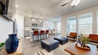 This two-story home offers a well-organized layout across two floors, with the main living areas on the ground floor and private quarters above. The open-concept ground floor seamlessly connects the kitchen, dining area, and living room, creating a bright and functional space ideal for everyday living and entertaining. The kitchen is outfitted with gray shaker-style cabinetry, white quartz countertops, stainless steel appliances including a gas range and French door refrigerator, and a central island with bar seating. The adjacent dining area features large windows that invite natural light and outdoor views, while the living room benefits from a ceiling fan and additional windows that enhance the airy atmosphere. A dedicated laundry room with full hookups is also found on this level.

Upstairs, the spacious primary bedroom includes a generous walk-in closet with built-in shelving and hanging rods, along with a private en-suite bathroom featuring a glass-enclosed walk-in shower and gray vanity cabinetry. A second bedroom with a reach-in closet, a full second bathroom, and a private office with carpet flooring and a ceiling fan complete the upper level. Wood-look flooring flows throughout the main areas, while plush carpet adds comfort to the bedrooms and office.