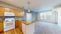 Located at 3700 Huset Pkwy NE in Columbia Heights, Minnesota, this two-bedroom, two-bathroom residence offers a well-designed single-floor layout with a comfortable and functional living environment. The open-concept kitchen and living area serves as the heart of the home, where warm honey-toned cabinetry, granite countertops, and a peninsula island with pendant lighting create an inviting culinary space. Wood-style flooring runs through the kitchen and entry areas, while plush carpet extends into the living room and bedrooms. A large window in the living room floods the space with natural light, and a door provides direct outdoor access. The primary bedroom is a generously sized retreat featuring a dedicated closet and its own natural light source. The second bedroom also offers comfortable proportions and includes a built-in closet with double doors. A walk-in closet with extensive wire shelving provides additional storage capacity. Both bathrooms are finished with wood-toned vanities and light countertops; one includes a full soaking tub and shower combination, while the other features a clean, open layout. A connecting hallway ties all rooms together efficiently, contributing to the practical and cohesive flow of the overall floor plan.