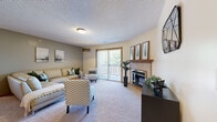 Located at 701 Pebblebrook Cir in Manhattan, Kansas, this single-floor residence offers a thoughtfully designed layout with comfortable living spaces and functional details throughout. The living room serves as a welcoming centerpiece, featuring plush carpeting, a wood-trimmed fireplace, and a sliding glass door that opens to a private balcony with outdoor views, filling the room with natural light. Warm, neutral tones and textured ceilings carry through the space, creating a consistent and cozy atmosphere. The kitchen is equipped with rich oak cabinetry, ample counter space, and a full suite of appliances, providing everything needed for everyday meal preparation. Adjacent to the kitchen, the dining area features wood-look flooring and an overhead light fixture, making it an ideal space for gathering. The bedrooms are generously sized, each with plush carpet and ceiling fans. Several bedrooms include walk-in or reach-in closets, offering practical storage solutions. The bathroom is well-appointed with a full tub and shower combination, an oak vanity with a wide mirror, and tile flooring. Warm wood door trim and oak accents are consistent design elements that tie the home together, lending a classic and inviting character throughout every room.