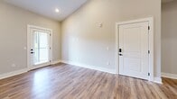 Located at 8651 Airway Dr in Pensacola, Florida, this well-appointed single-story home offers three bedrooms, one bathroom, and a thoughtfully designed layout. Warm wood-look flooring runs throughout the entire home, providing a cohesive and inviting aesthetic across every room.

The kitchen is a standout feature, showcasing crisp white shaker cabinetry with matte black hardware, elegant quartz countertops with subtle veining, and a full suite of stainless steel appliances including a gas range, microwave, and refrigerator. A striking blue kitchen island with a built-in sink and matching quartz surface serves as a functional centerpiece, while elevated ceilings lend an open, airy feel to the space. A stacked washer and dryer unit is conveniently positioned nearby.

The living area connects naturally to the kitchen and entry, offering a bright and accessible flow. The primary bedroom is generously sized, featuring dual windows that invite natural light and views of the surrounding greenery. The additional bedrooms are well-proportioned, each with windows fitted with blinds providing privacy and light control. A dedicated closet area includes built-in cabinetry with ample storage. Throughout the home, neutral gray and warm beige tones create a clean, modern backdrop ready for personalization.