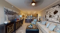 Located at 299 Squires Cir in Lexington, KY, this single-floor residence offers a cohesive open-concept layout that seamlessly connects the living, dining, and kitchen areas. The living room is highlighted by crown molding, a ceiling fan, and tasteful décor, flowing naturally into a well-equipped kitchen featuring rich walnut-toned cabinetry, granite countertops, a subway tile backsplash, and stainless steel appliances. A breakfast bar with pendant lighting provides casual seating while maintaining visual continuity throughout the space. The bedroom offers a comfortable retreat with wood-look flooring, natural light from a double window, and ample wall space. A walk-in closet with wire shelving systems provides generous storage. Two bathrooms mirror the kitchen's design aesthetic, both finished with granite-topped dark wood vanities and tile flooring — one featuring a glass-enclosed walk-in shower, and the other a full tub-shower combination. A dedicated laundry room with full-size washer and dryer hookups adds everyday convenience. Throughout the home, neutral tones, crown molding, and consistent flooring create a polished, unified aesthetic well-suited to a variety of lifestyles.