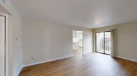 This single-story, 2-bedroom, 1-bathroom home offers a practical and comfortable layout across a well-proportioned floor plan. The great room serves as the heart of the home, featuring warm wood-look flooring, neutral beige walls, and a sliding glass door that opens directly to a private patio, allowing natural light to flow in. The space connects seamlessly to the kitchen area, which includes a peninsula with a breakfast bar overhang, white cabinetry, light countertops, a white appliance suite, and a window that brightens the space.

A dedicated pantry and in-unit laundry add to the home's functionality. A hallway connects the living areas to the private quarters, where two carpeted bedrooms offer a quiet retreat. The primary bedroom includes a ceiling fan, a window with outdoor views, and a built-in closet. The second bedroom also features carpeted flooring, a window, and ample wall space. Additional closets throughout the home provide generous storage. The full bathroom is finished with tile flooring, a tub and shower combination with grab bars, a frosted window, and a vanity area. Clean lines, consistent neutral tones, and practical finishes give the home a cohesive, move-in ready character throughout.