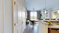 Located at 363 Granello Ave in Coral Gables, FL, this well-appointed single-floor residence offers three bedrooms and two bathrooms with a thoughtfully designed layout. The open-concept kitchen and living area serves as the heart of the home, featuring dark espresso cabinetry, stainless steel appliances, a mosaic tile backsplash, and a granite breakfast bar with pendant lighting overhead. The living room is bright and inviting, with a ceiling fan, neutral tones, and sliding glass doors that open to a balcony with open views of the surrounding area. The primary bedroom is a spacious retreat highlighted by a rich wood-paneled accent wall and access to a generous walk-in closet with floor-to-ceiling shelving systems and wood-look flooring. The two bathrooms are finished with large-format tile flooring and dark wood vanities with white countertops; one features a glass-enclosed walk-in shower, while the other includes a full soaking tub with a shower curtain enclosure. A secondary closet provides additional storage. Light wood-tone flooring flows throughout the common areas and bedrooms, lending a warm, cohesive feel to the entire residence. The overall ambiance is contemporary and refined, ideal for comfortable urban living in one of Miami's most desirable neighborhoods.