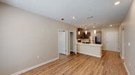 This single-story, two-bedroom, two-bathroom residence in Baton Rouge, Louisiana, offers a thoughtfully designed open-concept layout finished with warm, neutral tones throughout. Wood-style plank flooring extends across the main living areas and bedrooms, complementing the clean, contemporary aesthetic.

The kitchen serves as the focal point of the living space, featuring a peninsula with a built-in sink and dishwasher, stainless steel appliances including a refrigerator, range, and microwave, and rich dark cabinetry paired with light countertops. Pendant lighting above the peninsula adds a polished touch. The kitchen opens directly to the living area, which receives natural light from multiple windows.

Both bedrooms offer comfortable proportions, recessed lighting, and closet access. The primary bathroom includes a vanity with dark cabinetry, a tub-shower combination, and tile flooring, with a walk-in closet accessible from within. The second bathroom mirrors this design. A dedicated in-unit stacked washer and dryer is conveniently located in a closet near the main living area, adding practical functionality to the overall layout.