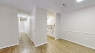 This single-floor, 2-bedroom, 1-bathroom home offers a clean, modern aesthetic throughout. Light-toned luxury vinyl plank flooring runs through the main living areas, kitchen, and hallway, while plush carpeting provides comfort in both bedrooms. The open living area is anchored by a ceiling fan with lighting and a textured ceiling, and features a paneled entry door that welcomes natural light into the space.

The galley-style kitchen is efficiently designed with white shaker cabinetry, black hardware, marble-look countertops, a stainless steel sink, and a full suite of appliances including a refrigerator, range, and dishwasher. Adjacent to the kitchen, a hallway connects the main living areas to the bedrooms, bathroom, and two closets, providing excellent storage and organization.

The spacious primary bedroom offers generous square footage, soft carpeting, and a large window fitted with blinds that allows ample natural light while maintaining privacy. The second bedroom mirrors this bright, comfortable character with its own window and carpeted floor. The bathroom features clean white cabinetry with brushed nickel hardware and a six-panel interior door. Throughout, neutral wall tones and consistent finishes create a cohesive, move-in ready environment.