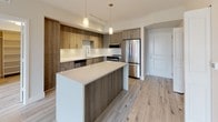Located at 4200 NW 107 Ave in Doral, Florida, this single-floor unit showcases a clean, modern design throughout. Light wood-look flooring runs seamlessly across the entire space, creating a cohesive and bright aesthetic.

The kitchen is a standout feature, boasting wood-toned cabinetry with sleek hardware, a geometric-patterned tile backsplash, stainless steel appliances including a French door refrigerator, built-in microwave, and dishwasher, and a large center island with a white quartz countertop. Pendant lighting adds a refined touch above the island.

The open living area flows naturally from the kitchen, offering a generous, light-filled space with neutral walls and excellent layout flexibility. A laundry area is conveniently accessible from the main living space.

The bedrooms are spacious and bright, each featuring built-in closets with shelving systems for organized storage. Natural light enters through well-positioned windows.

The bathrooms reflect the same modern sensibility, with one featuring a soaking tub and shower combination finished in classic white subway tile and a wood-toned vanity with a white countertop. A second bathroom offers a frameless glass walk-in shower, also clad in white subway tile, providing a clean and contemporary finish throughout.
