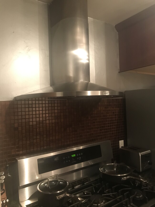 Stainless steel vent fan and hood , with beautiful copper/glass backsplash. - 1857 Pandora Ave