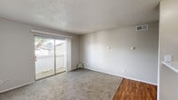 This well-organized 1-bedroom, 1-bathroom residence offers a practical and comfortable layout across a single floor. The living room serves as the focal point of the home, highlighted by a white-painted brick fireplace with shiplap surround and a sliding glass door that opens to a private balcony, allowing natural light and outdoor views to fill the space. Carpet flooring covers the living and bedroom areas, while wood-style flooring runs through the kitchen, hallway, and bathroom.

The galley-style kitchen is efficiently designed with white cabinetry, light stone-look countertops, a double-basin sink, and black appliances including a refrigerator, electric range, and dishwasher. A pass-through opening connects the kitchen to the main living area, enhancing the sense of openness. A window at the end of the kitchen provides additional natural light.

The bedroom is a well-proportioned, carpeted room with a window and a dedicated closet for storage. The bathroom features a full tub-shower combination with clean white tile surround and wood-style flooring. A textured popcorn ceiling is consistent throughout the residence. A hallway connects the main rooms, completing this efficiently arranged single-floor layout.