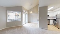 This single-floor residence at 8044 Pocket Rd in Sacramento's Pocket neighborhood offers a well-designed layout with a bright, open feel throughout. The living area is a standout, featuring dramatic vaulted ceilings with a ceiling fan and sliding glass doors that open to an outdoor balcony, flooding the space with natural light and providing views of the surrounding neighborhood. Soft carpet flooring adds warmth to the living and bedroom areas, while light hardwood-style flooring flows through the kitchen and bathrooms.

The kitchen is thoughtfully updated with crisp white shaker cabinetry, dark countertops, a herringbone tile backsplash, and a full suite of stainless steel appliances including a refrigerator, dishwasher, microwave, and range. The clean, modern aesthetic carries into the bathrooms, which feature white cabinetry, dark countertops, wide mirrors, and contemporary light fixtures.

The bedrooms are generously sized, with neutral tones and carpeted floors. One bedroom benefits from vaulted ceilings, adding an airy sense of volume. The overall color palette throughout the home is composed of soft grays and warm whites, creating a clean, neutral, and move-in-ready atmosphere ideal for a variety of living styles.