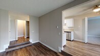 Located at 4200 SW 107th Ave in Beaverton, Oregon, this single-floor residence offers a well-organized layout designed for comfortable everyday living. The main living area features rich, dark wood-style flooring and neutral taupe walls that create a warm, cohesive atmosphere throughout. A sliding glass door fills the living space with natural light and provides direct access to an outdoor green area, enhancing the sense of openness. A wall-mounted HVAC unit and vertical blinds add practical functionality to the room.

The galley-style kitchen is efficiently designed with white shaker cabinetry, light countertops, and stainless steel appliances including a refrigerator, electric range, and dishwasher. A centrally positioned skylight-style ceiling fixture provides ample illumination, making the kitchen both bright and highly functional.

The bedrooms are finished with plush carpeting and neutral walls, offering a quiet, comfortable retreat. Each bedroom includes closet space, with one featuring classic bi-fold doors. Windows in the bedrooms bring in natural light and views of the surrounding neighborhood greenery.

The bathroom is cleanly appointed with a full tub and shower combination, a single vanity with a mirror, and brushed nickel fixtures. Textured ceilings are consistent throughout, and crisp white baseboards provide a clean finish to every room.